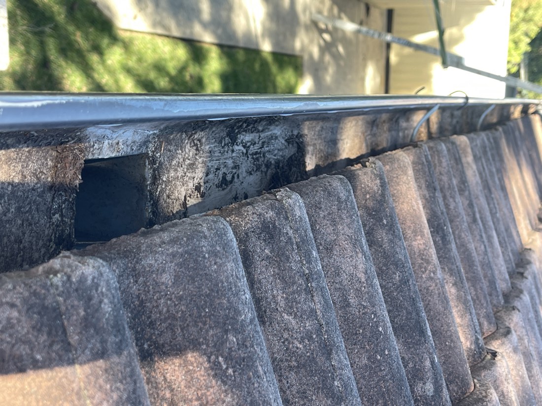 Close-up of blocked gutter downpipe before cleaning